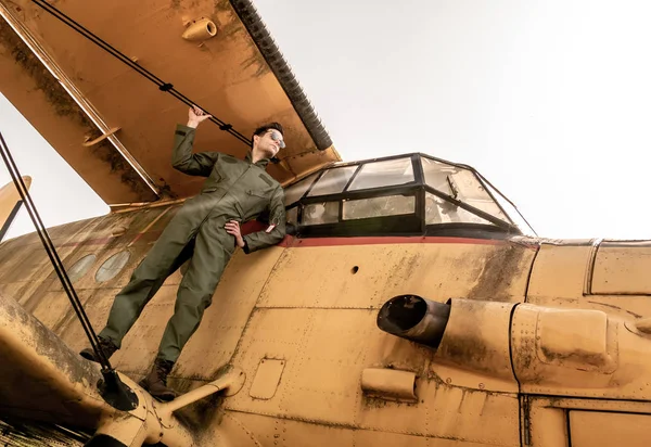 Um belo jovem piloto de pé na asa de um avião — Fotografia de Stock