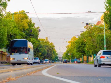 Sokaktan geçen arabalar ve tramvaylarla kavşağı seyret.