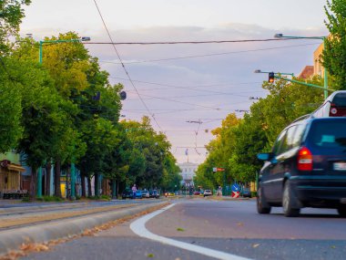 Sokaktan geçen arabalar ve tramvaylarla kavşağı seyret.