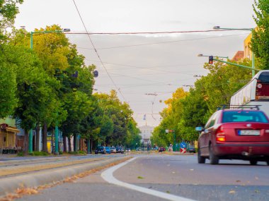 Sokaktan geçen arabalar ve tramvaylarla kavşağı seyret.
