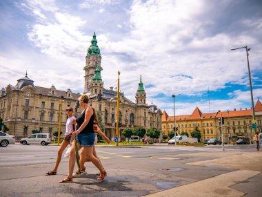 Belediye başkanının ofisinin önündeki insanlara ve arabalara bakın.