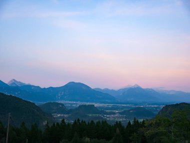 Görkemli tepelerin üzerinde L harfiyle güneşin doğuşunu izle.