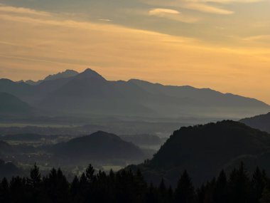 Görkemli tepelerin üzerinde L harfiyle güneşin doğuşunu izle.