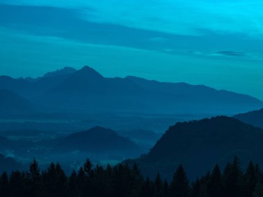 Görkemli tepelerin üzerinde L harfiyle güneşin doğuşunu izle.