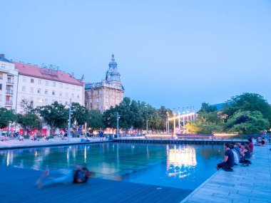 BUDAPEST, HUNGARY - 22 Ağustos 2020: İnsanlar Budapeşte, Macaristan 'da bir yaz akşamı Francis meydanında dinlenirken gün batımını izleyin.