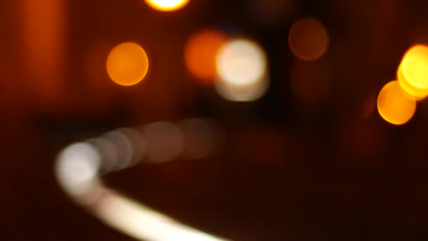 Размытая боке-сцена в городе ночью с теплыми красками, в то время как люди проходят мимо. — стоковое видео