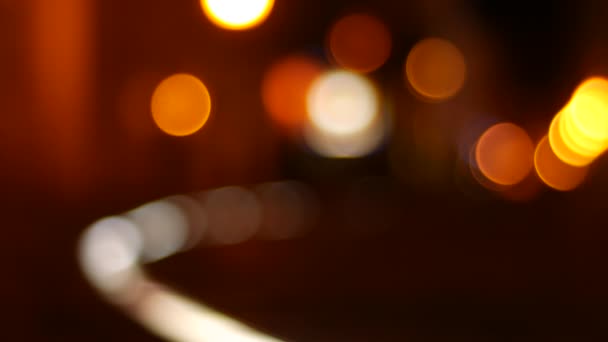 Blurry bokeh σκηνή στην πόλη τη νύχτα με ζεστά χρώματα, ενώ οι άνθρωποι περπατούν από. — Αρχείο Βίντεο