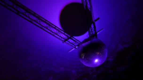 Filmato di una sfera a specchio rotante disco ball con riflessi da luci colorate sul tetto. — Video Stock