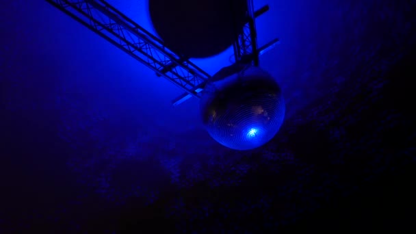 Filmato di una sfera a specchio rotante disco ball con riflessi da luci colorate sul tetto. — Video Stock