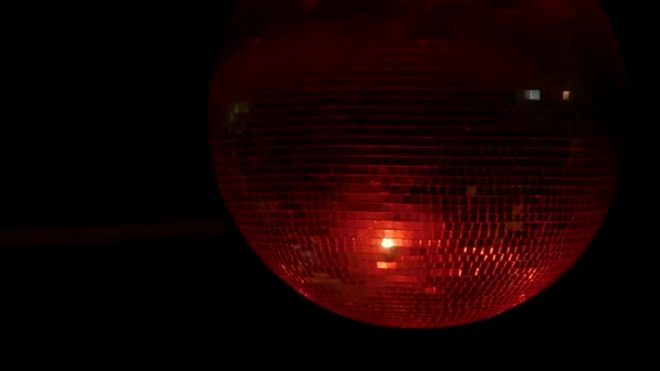 Närbild bilder av en snurrande speglad sfär disco boll med reflektioner av färgglada ljus. — Stockvideo