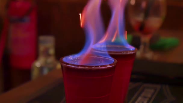 Filmaufnahme eines brennenden, funkelnden alkoholischen Getränks in einem Schnapsglas in einem Nachtclub. — Stockvideo