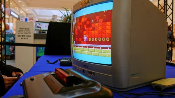 SZEKESFEHERVAR, WĘGRY - 16 marca 2019: Zobacz na konsoli gier retro rozegranej na starym telewizorze podczas wystawy gier w Alba Plaza SZEKESFEHERVAR, WĘGRY — Wideo stockowe