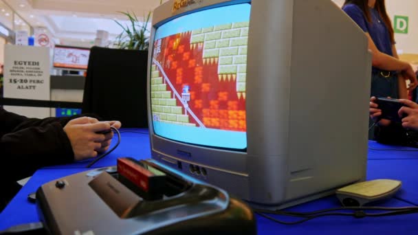 SEZKESFEHERVAR, HUNGARY - 2019年3月16日:ハンガリーのアルバ・プラザSZEKESFEHERVARで開催されたゲーム展示会で、古いテレビで再生されたレトロゲームコンソールゲームを見る — ストック動画