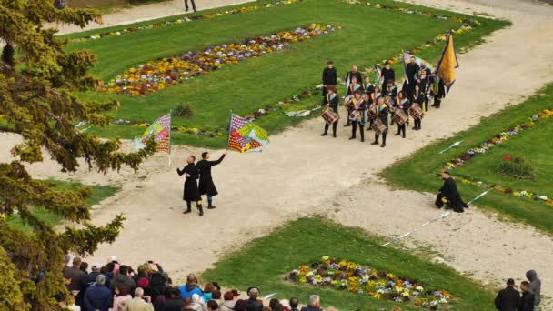 VARPALOTA, HUNGARY - APRIL 13, 2019: 사람들이 이 탈리아의 날들을 기념하기 위해 헝가리, 바르 팔로타의 배경에서 드럼 연주자들과 함께 플래그를 연주하고 흔들고 있다. — 비디오