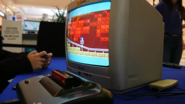SZEKESFEHERVAR, HUNGARY - 2019年3月16日:ハンガリーのアルバ・プラザSZEKESFEHERVARで開催されたゲーム展示会で、古いテレビで再生されたレトロゲームコンソールゲームを見る — ストック動画