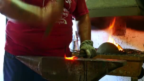 SZEKESFEHERVAR, HUNGARY - JUNE 22,2019: View on a traditional blacksmith while shaping the burning iron in Szekesfehervar, Hungary during the event Fire and Iron festival. — Stock Video