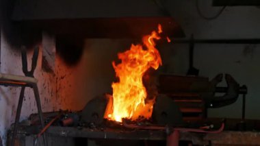 Yanan ateşe ve demircideki ocağa bakın..