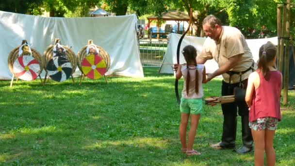 SEZKESFEHERVAR, HUNGARY - 2019年8月19日:晴れた夏の日にイベント中の中世の王の日にハンガリーのSzekesfehervarでターゲットに矢を射る子供. — ストック動画