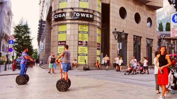 BUDAPEST, HUNGRÍA - 30 de agosto de 2019: Vea a las personas que usan scooter eléctrico en la calle Vaci en una tarde de verano en Budapest, Hungría. — Vídeos de Stock