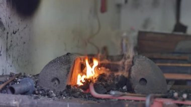 Yanan ateşe ve demircideki ocağa bakın..