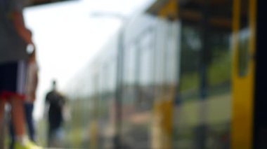 Gündüz vakti insanlar treni beklerken şehirde bulanık görüntüler..