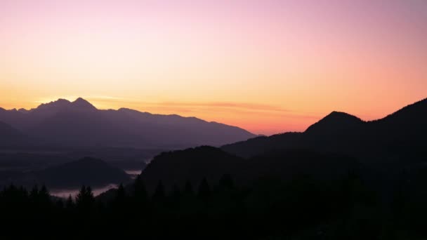 Time-lapse uitzicht op de prachtige zonsopgang over de majestueuze heuvels met het meer Bled in Slovenië op een koude mistige ochtend. — Stockvideo