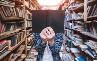 Genç bir adam rahat, eski, genel Bülteni anlamına gelir ve bir kitap yüzünün önünde tutar. Öğrenci kitap ile yüzünü kapatır. Yüz kitap.