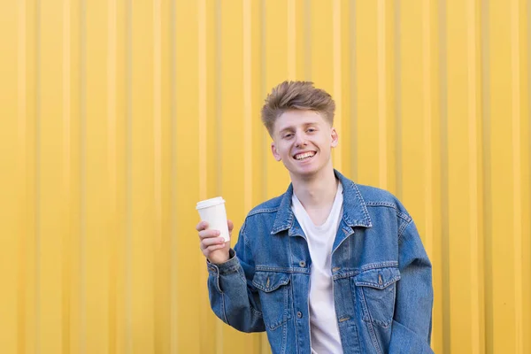 Glücklicher Junger Mann Der Mit Einer Tasse Kaffee Auf Gelbem — Stockfoto