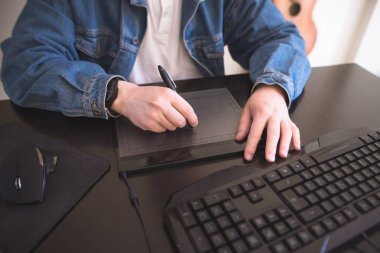 Bir grafik tablet üzerinde çalışan bir erkeğin elinde. Serbest tasarımcı bilgisayar yakın çekim üzerinde çalışması.