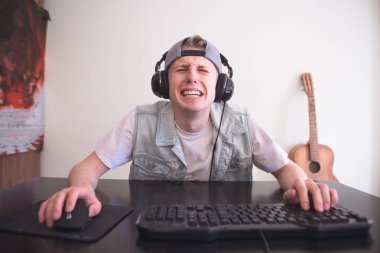 Üzgün oyun evde bilgisayar ve video oyun yenilgisinden çığlıkları arkasında oturuyor. Bir bilgisayar oyunu kaybeden bir komik hüzünlü genç portresi. Oyun kavramı