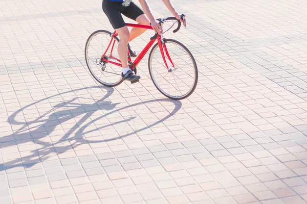 自転車に乗って都市広場舗装赤い自転車 現代的なコンセプト バイクと舗道に影 — ストック写真