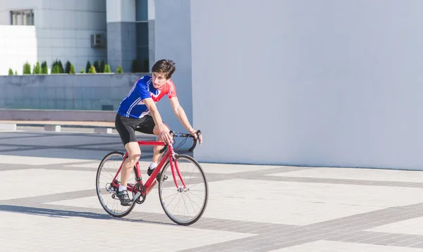 Ein Mann Sportkleidung Fährt Ein Rotes Rennrad Vor Dem Hintergrund — Stockfoto