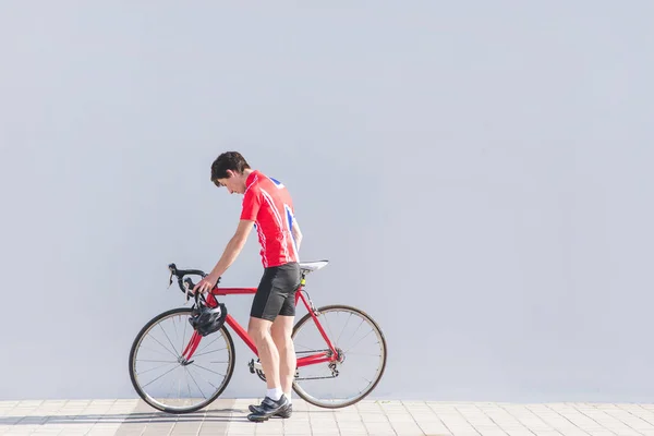 Sportler Radfahrer Mit Rotem Rennrad Vor Grauer Wand Kopierraum Sportkonzept — Stockfoto
