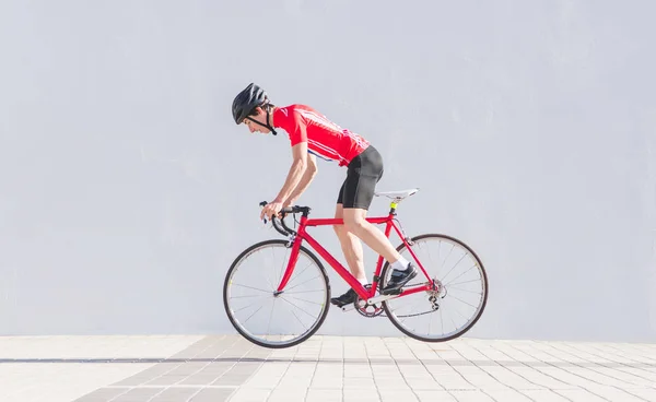 Radler Mit Helm Und Fahrradkleidung Springen Auf Ein Rotes Rennrad — Stockfoto