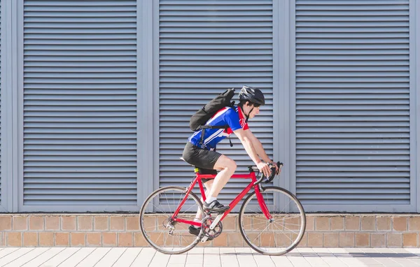 Ciclista Bicicletta Uno Zaino Cavalca Una Bici Strada Uno Sfondo — Foto Stock