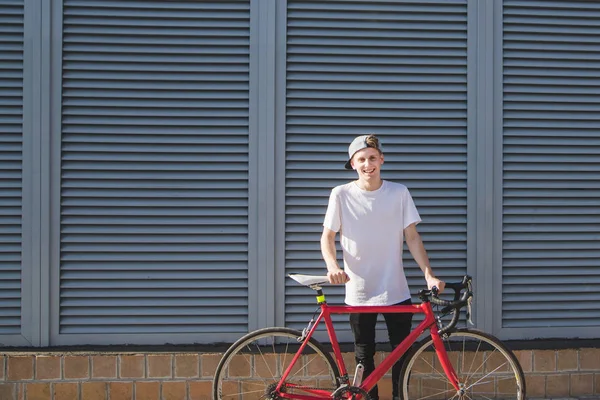 Retrato Homem Bonito Sorridente Uma Bicicleta Fundo Paredes Cinzas Hipster — Fotografia de Stock