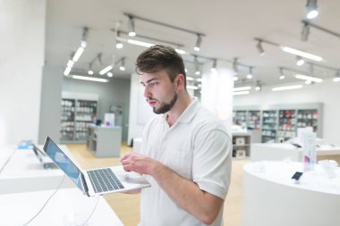 Yakışıklı bir defter bir ışık teknolojisi deposunu kullanır. Bir alıcı bir defter bir modern elektronik mağazasında seçer. Bir dizüstü bilgisayar satın.