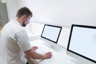Bir sakallı bir teknoloji Mağazası beyaz bir ekran ile bir bilgisayar monoblok kullanır. Işık elektronik mağazasından bir bilgisayar seçiminde.