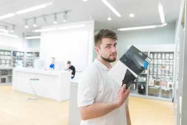 adam bir tablet durumda bir teknoloji mağaza standları ve kameraya benziyor. Araç aksesuarları modern elektronik mağazasında satın.