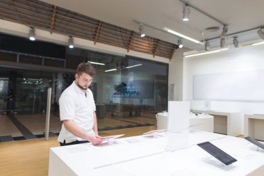 Dükkanı pencerenin önünde duruyor ve becerikli alet seçer erkek portre. Bir şık, hafif tasarım araçlarını elektronik mağazasından, alıcı bakar