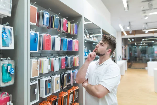 Homem Atencioso Escolhe Casos Smartphone Departamento Acessórios Loja Eletrônica Moderna — Fotografia de Stock