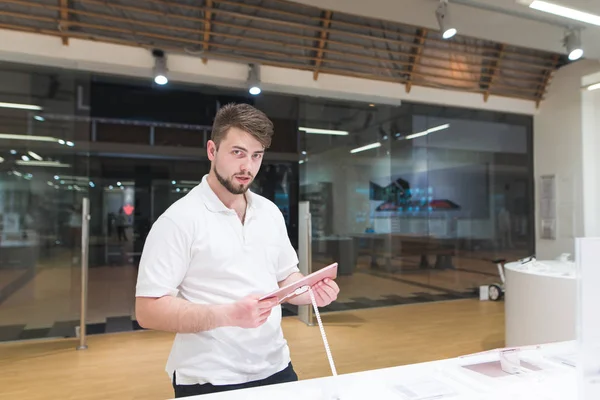 Dükkanı pencerenin önünde duruyor ve becerikli alet seçer erkek portre. Bir şık, hafif tasarım araçlarını elektronik mağazasından, alıcı bakar