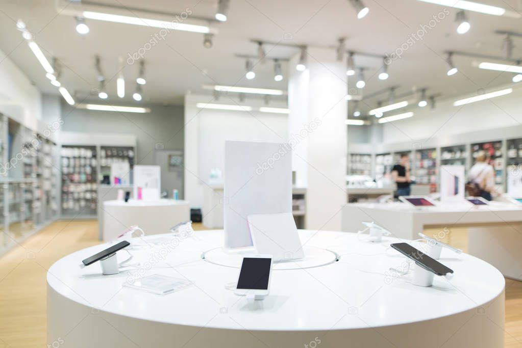 Showcase with smartphones in the modern electronics store. Buy a mobile phone. Many smartphones on the shelf of the technology store.