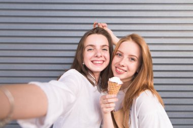 Çekici genç kız selfie arka plan gri duvarlar üzerinde yapıyor. Parlak elbise sevimli mutlu genç kadınlarda selfie karanlık bir arka plan üzerinde olun..