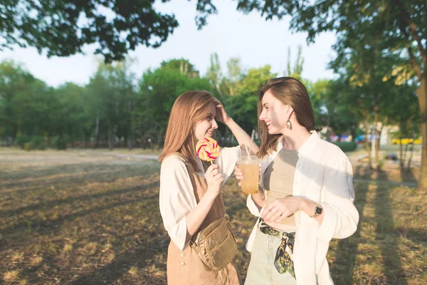Šťastný Stylové Dívky Jsou Parku Limonádu Čokoládu Jejich Rukou Komunikovat — Stock fotografie