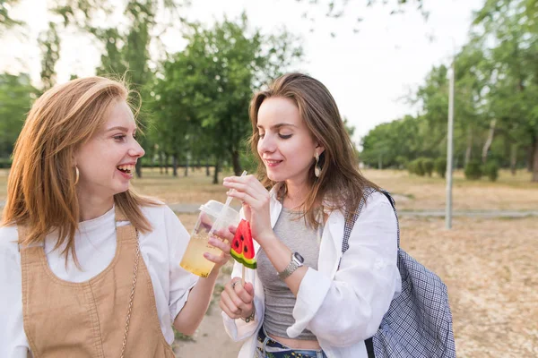 Két Pozitív Lányok Limonádét Egy Nyalóka Sétálni Parkban Park Stílusos — Stock Fotó