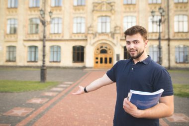 Mutlu bir adam öğrenci üniversiteye davet ediyor. Kitaplar ve onun dizüstü bilgisayarlar ile gülümseyen bir öğrenci portresi üniversiteye girişte duran eller ve eliyle davet ediyor
