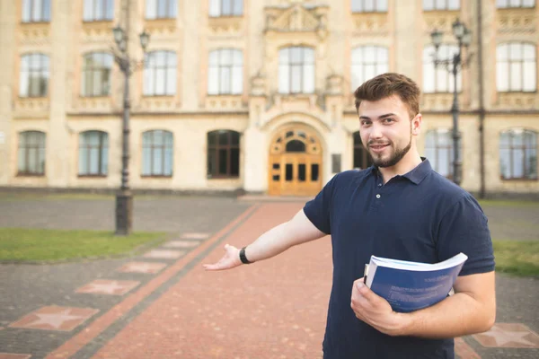 Mutlu bir adam öğrenci üniversiteye davet ediyor. Kitaplar ve onun dizüstü bilgisayarlar ile gülümseyen bir öğrenci portresi üniversiteye girişte duran eller ve eliyle davet ediyor