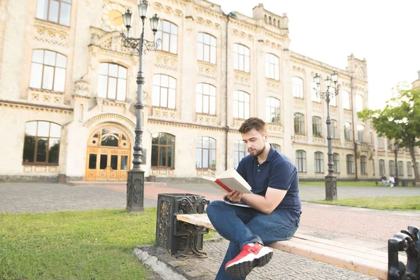 Концентрированный Студент Сидящий Фоне Университета Читающий Книгу Человек Бородой Сидит — стоковое фото