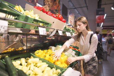 Biber süpermarket sebze bölümünde satın şık bir kız portresi. Çekici kadın mağaza sebze satın alır. Marketteki ürünlerin satın alma.